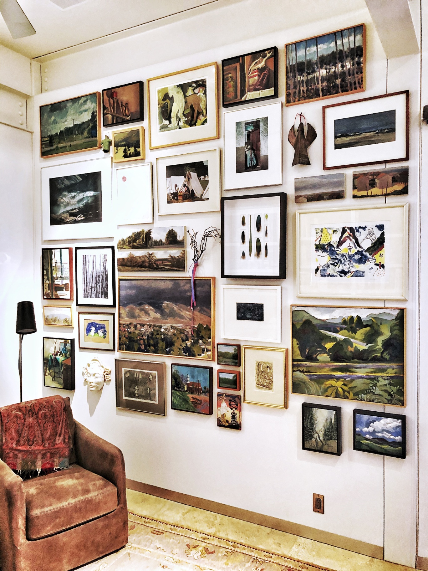 Curated salon-style gallery wall installed in a collector's home